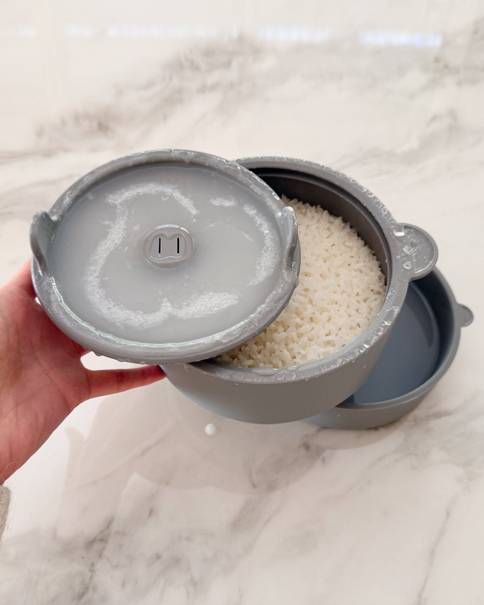 Calopig Low Sugar Rice Cooker | Silicone Microwave Steamer in Grey showing cooked rice and drained starchy water