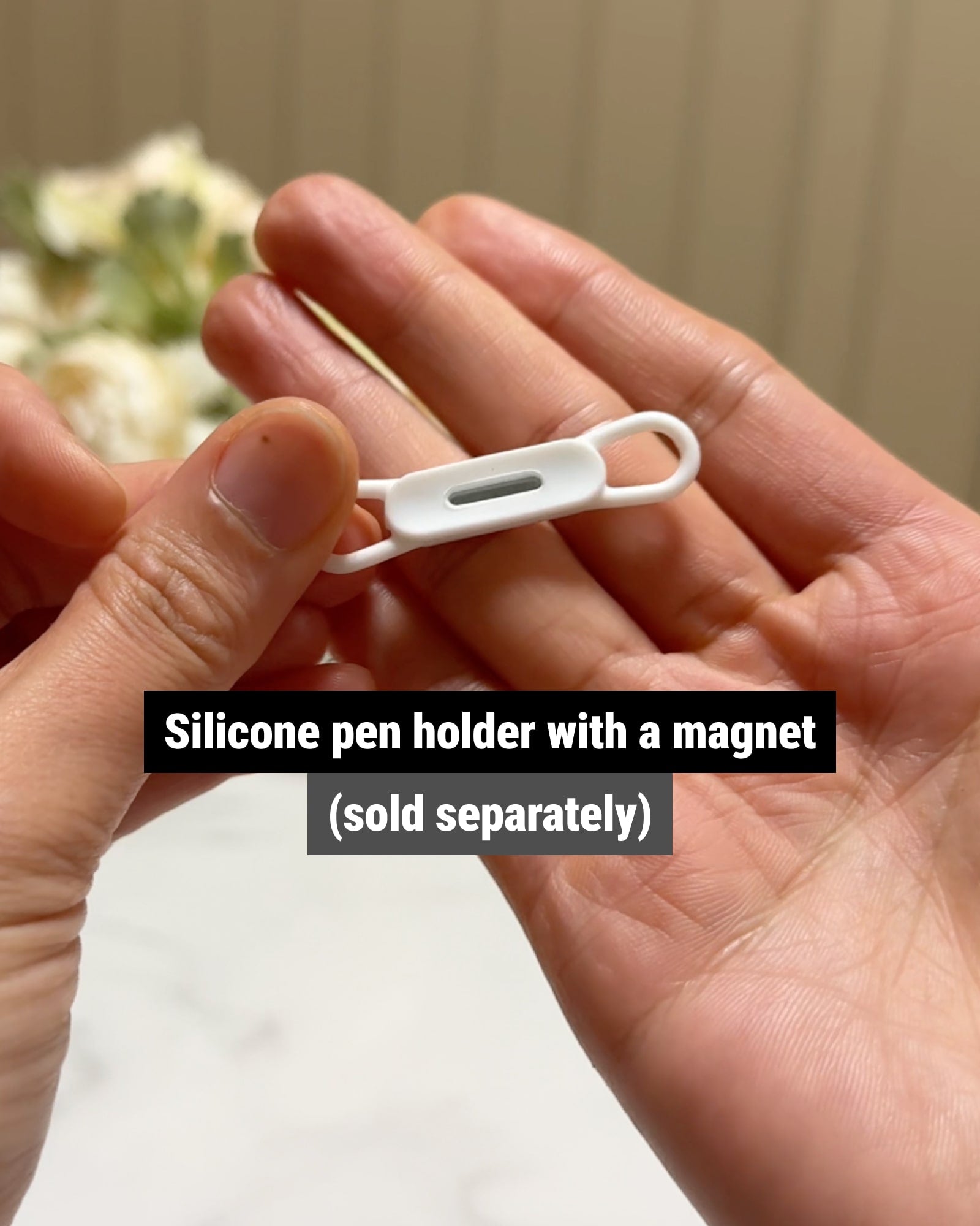 A small silicone pen holder with a magnet for storing a pen on appliances like a fridge.