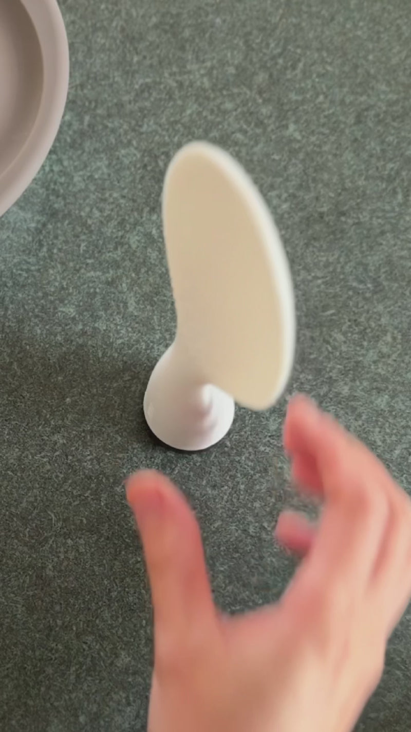 A white rice scooper standing on a kitchen top